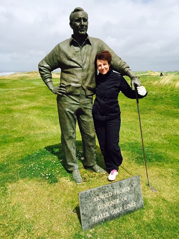 Golfeurse posant à côté de la statue d'Arnold Palmer